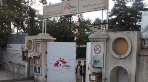 Afghan guards stand at the gate of MSF hospital after an air strike in the city of Kunduz