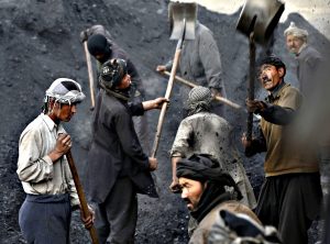 Labourers shovel coal onto a truck at a coal dump site outside Kabul...Labourers shovel coal onto a truck at a coal dump site outside Kabul January 19, 2015. Each labourer earns an average of $10 per working day, with most of them coming come from the northern provinces, leaving their families behind to find work in the capital.   REUTERS/Mohammad Ismail (AFGHANISTAN - Tags: BUSINESS EMPLOYMENT)