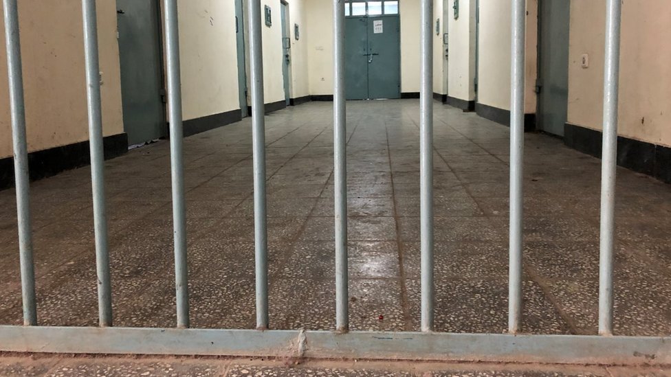 A long hallway behind bars