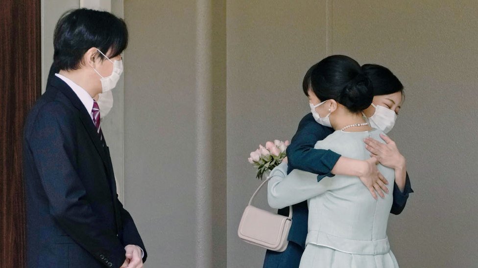 Japan's Princess Mako (R) hugs her sister Princess Kako (2nd R) before leaving her home at Akasaka Estate in Tokyo on October 26, 2021